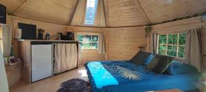 a bedroom with a bed in a wooden cabin at Cabane Kota finlandais in Laives
