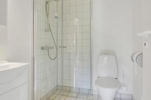 uma casa de banho com um chuveiro e um WC. em Den Gamle Kro Hornslet em Hornslet