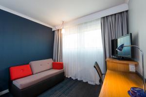 a living room with a couch and a television at Holiday Inn Express Swansea East by IHG in Swansea