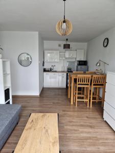 kuchnia i salon ze stołem i kanapą w obiekcie Jakuba Wejhera 5c 10 w Gdańsku