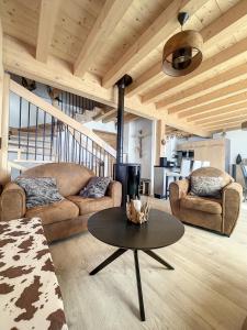 a living room with two couches and a table at Chalet La Galise in La Toussuire