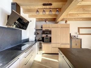 a kitchen with wooden cabinets and a black counter top at Chalet La Galise in La Toussuire