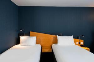 two beds sitting next to each other in a room at Holiday Inn Express Swansea East by IHG in Swansea +39 photos