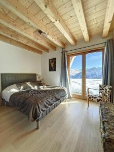 - une chambre avec un lit et une grande fenêtre dans l'établissement Chalet La Galise, à La Toussuire