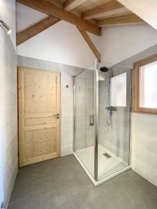 a bathroom with a shower with a glass door at Chalet La Galise in La Toussuire