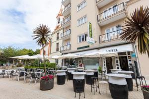 un grupo de mesas y sillas frente a un hotel en Hotel Ros Mary, en Ribadeo