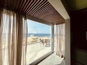 a room with a large window with a view of the ocean at Salini Suites in Żebbuġ