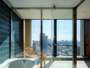 THE AOYAMA GRAND HOTEL في طوكيو: حوض استحمام في غرفة مع نافذة كبيرة