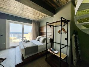 Schlafzimmer mit einem Bett und Meerblick in der Unterkunft Salini Suites in Żebbuġ