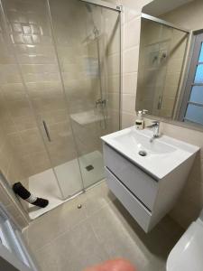 y baño blanco con lavabo y ducha. en Ca La Rubia en Benifairó de Les Valls