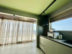 a kitchen with a window with a view of the ocean at Salini Suites in Żebbuġ