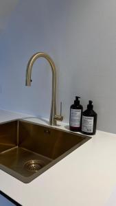 a kitchen sink with two bottles of soap on it at STAY Penthouse in Kolding