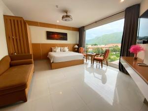 um quarto de hotel com uma cama, uma mesa e cadeiras em Conson Hotel em Con Dao