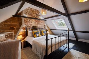a bedroom with a bed and a brick wall at Host & Stay - Atlanta Cottage in Hawsker