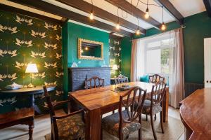 a dining room with green walls and a wooden table and chairs at Host & Stay - Atlanta Cottage in Hawsker