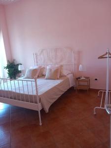 a bedroom with a bed with a white bed frame at La Suite dei Ricami in Agrigento