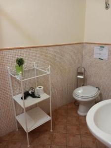a bathroom with a white toilet and a sink at La Suite dei Ricami in Agrigento
