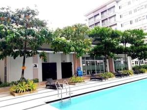 um hotel com piscina em frente a um edifício em Trees Residence in Quezon City with balcony. em Manila