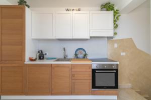 Una cocina con gabinetes blancos y un horno de estufa. en Appartamento Greta vista mare, en Marina di Noto 24 fotos más