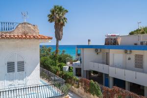 un edificio con una palmera y el océano en el fondo en Appartamento Greta vista mare, en Marina di Noto