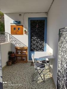 a table and a chair in front of a door at Neoclassical Samos House Nafsika in Samos