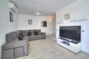 een woonkamer met een bank en een flatscreen-tv bij Ocean Hill - Ocean View, Terrace, BBQ, WIFI in Adeje