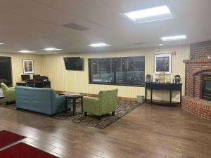 a waiting room with chairs and a fireplace at SureStay by Best Western Grayson in Grayson