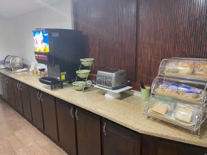a kitchen counter with a television and food on it at SureStay by Best Western Grayson in Grayson