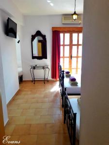 ein Wohnzimmer mit einem Tisch, Stühlen und einem Spiegel in der Unterkunft EVANS Skiathos in Skiathos-Stadt
