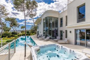 einen Außenblick auf ein Haus mit einem Whirlpool in der Unterkunft Luxueuse Villa Charleston - Vue mer, Sauna Hammam in Antibes