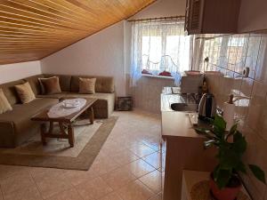 Guesthouse Centro في موستار: غرفة معيشة مع أريكة وطاولة