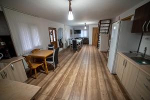 a kitchen and living room with a table and refrigerator at Cabana Tatiana in Avrămeşti