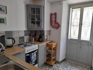 a kitchen with a stove and a sink and a window at Beau Maison in Le Vigeant