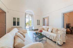 a living room with a white couch and a table at HelloApulia Il Mirteto in Selva di Fasano