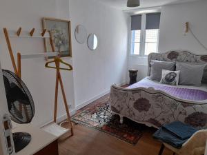 a living room with a bed and a window at Beau Maison in Le Vigeant
