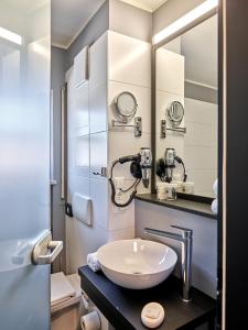 a bathroom with a sink and a mirror at Hotel Innsento - Health Campus Passau in Passau