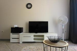 ein Wohnzimmer mit einem weißen Entertainment-Center mit einem Flachbild-TV in der Unterkunft Amazing Sea View Kamenovo in Becici