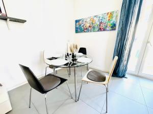 una sala da pranzo con tavolo in vetro e sedie di Cinque Terre Luxury Home a La Spezia