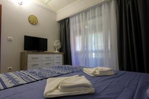 ein Schlafzimmer mit einem blauen Bett und Handtüchern darauf in der Unterkunft Amazing Sea View Kamenovo in Becici