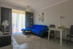 ein Wohnzimmer mit einem blauen Sofa und einem Tisch in der Unterkunft Amazing Sea View Kamenovo in Becici