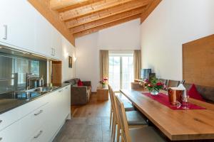 eine Küche und ein Wohnzimmer mit einem Holztisch in der Unterkunft Appartements Ferienwohnungen Unser Unterberg in Maria Alm am Steinernen Meer