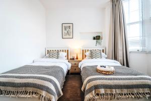 - une chambre avec 2 lits et une fenêtre dans l'établissement Principality View Apartment One, by Solace Stays, à Cardiff