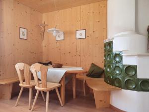 een eetkamer met een tafel en stoelen en een fornuis bij Für 4-6 Wohnhaus im Weinberg - Voldersberghof in Penone