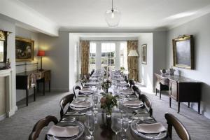 a long dining room with a long table and chairs at Butley Priory Farmhouse 12 in Woodbridge