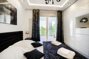 About Art Apartments - Sikorskiego في فروتسواف: غرفة نوم مع سرير مع وسائد سوداء وبيضاء