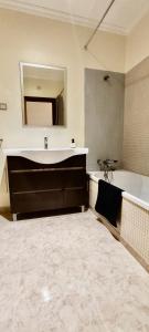 a bathroom with a sink and a tub and a mirror at APARTAMENTO DO LAGAR in Algoz