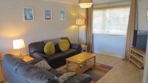 ein Wohnzimmer mit Sofa und Fernseher in der Unterkunft Poplars in Aldeburgh