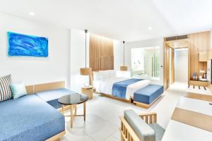 a hotel room with a bed and a couch at Ace of Hua Hin Resort - SHA PLUS in Cha Am