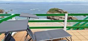 una silla sentada en un balcón con vistas al océano en Rincón de Mar - En Playa Estaño, en Gijón