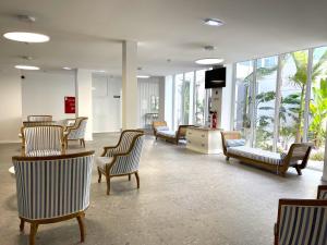 a waiting room with chairs and tables and windows at Ocean View Apartments in Lourinhã